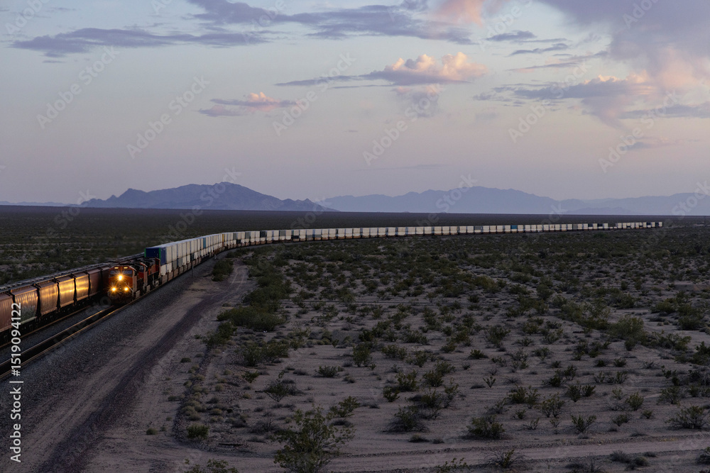 Obraz premium Trains in distance of desert landscape at dusk