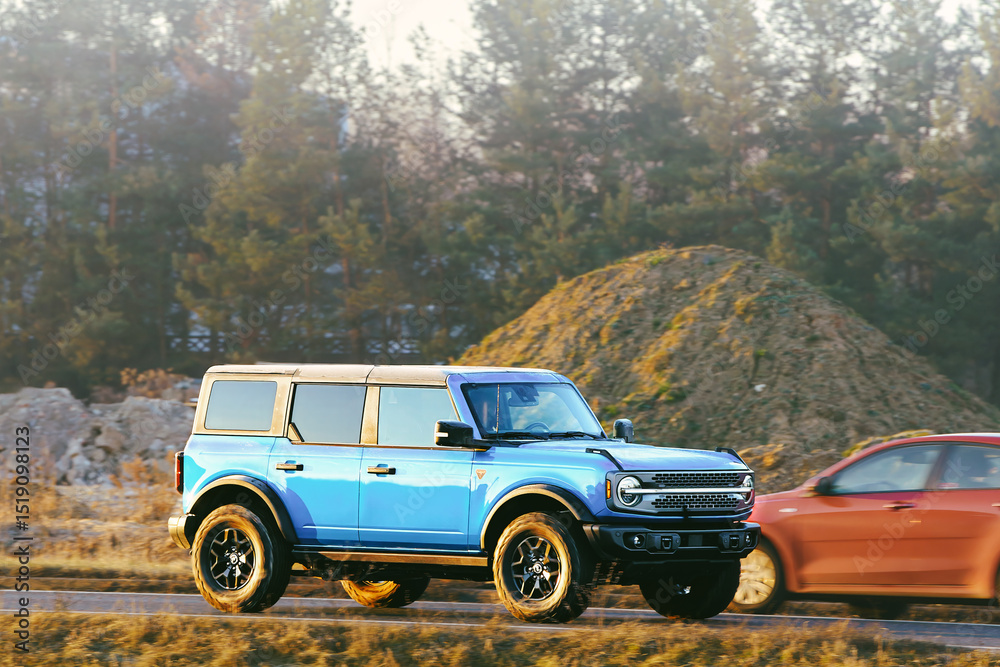 Fototapeta premium Blue four-wheel-drive SUV on dirt path