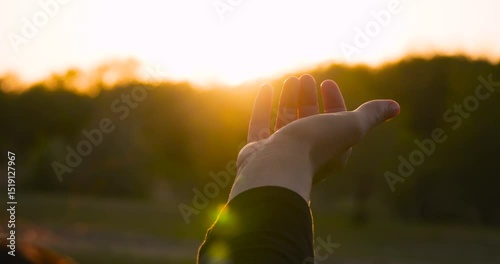 Open hand in golden sunset close-up. palm at sunset human connection with nature. peace and harmony through open hand energy of the surrounding world