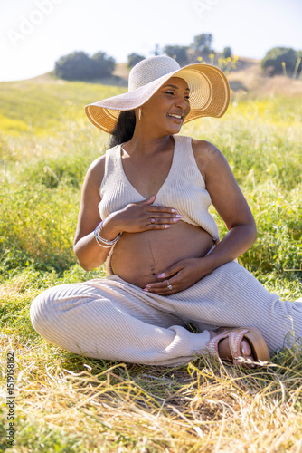 A beautiful pregnant woman enjoying a delightful sunny day outdoors, completely surrounded by nature, and embodying pure joy and serenity throughout her pregnancy journey and experience