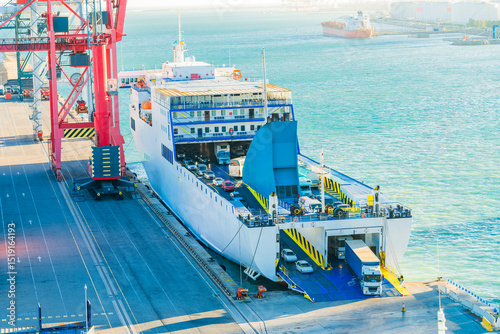 Roll-on roll-off ferry loading vehicles at port terminal, photo