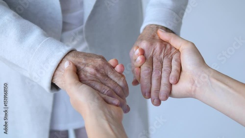 Compassionate young woman gently holding wrinkled hands of elderly person, symbolizing support, care, and deep emotional connection between generations