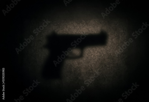 Silhouette shadow of a handgun cast against a dimly lit textured wall, evoking tension and symbolic threat under low light.
