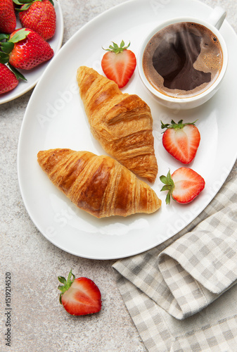 Delicious french breakfast with coffee, croissants and fresh strawberries