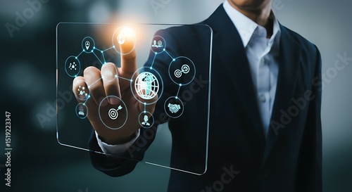 A businessman in a suit interacts with a transparent digital interface displaying a network of interconnected business icons.