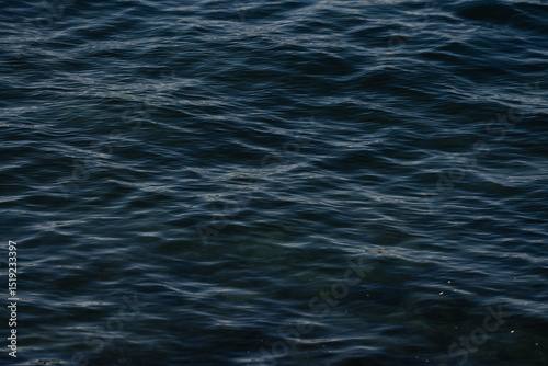 Dark blue wavy water surface creates a moody atmosphere