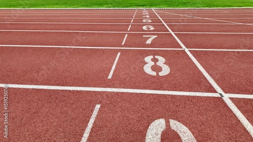 Footage of a red running track with numbered starting lines outdoors.