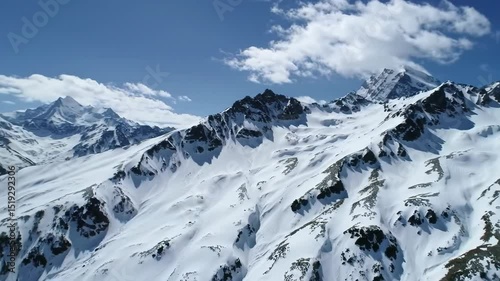 Aerial View of Snowy Mountain Peaks Under a Clear Sky
