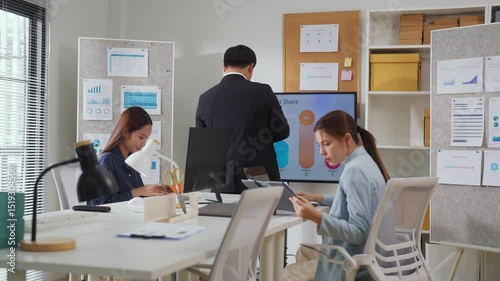 professional coworkers collaborates around a table in a modern office, actively brainstorming and discussing ideas for a new project. The team, including men and women, engages in a web conference 