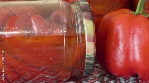 canned pepper in jars, a table with pickled jars of sweet red pepper for the winter