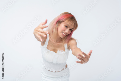Friendly young Asian woman reaches forward with outstretched arms, exuding warmth, openness, and chummy energy. Isolated on a light background.