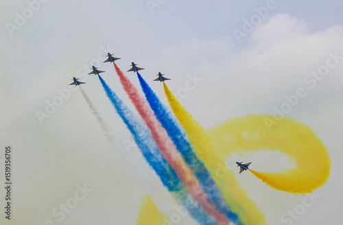 J-10 Acrobatic airshow team from China Air Force on formations with colorful smokes venting from the plane.