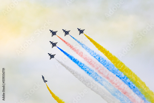J-10 Acrobatic airshow team from China Air Force on formations with colorful smokes venting from the plane.