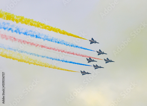J-10 Acrobatic airshow team from China Air Force on formations with colorful smokes venting from the plane.