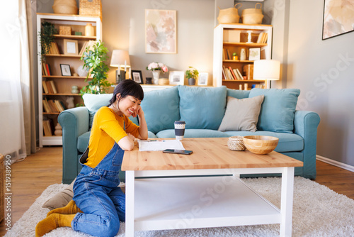 Woman reading magazine and drinking coffee while relaxing at home
