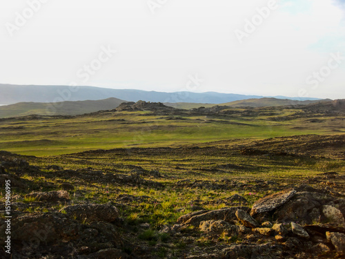 Evening light over the rocky steppe of Olkhon Island, Lake Baikal. Soft shadows highlight the texture of the terrain and distant hills.