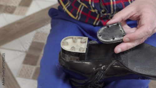 glue the heel of boots, a shoemaker glues women's boots, repair of old worn-out shoes