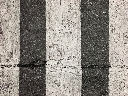Worn Black and White Road Markings with Cracks