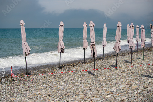 Fototapeta Naklejka Na Ścianę i Meble -  A beach with a row of umbrellas on the sand