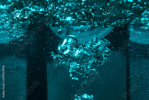 texture of the water is a rumbling chaos with bubbles created by the air escaping outside in the blue light