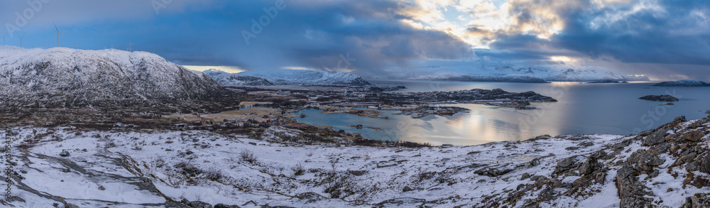 Obraz premium impressive, changing weather moods on the fjord between steep, snow-covered mountains around the island Kvaloya in Troms, Norway. Panorama with sea, dark clouds on the sky and snowy mountains