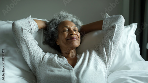 Black grandmother enjoys a peaceful moment stretching in bed during a bright morning in a cozy bedroom