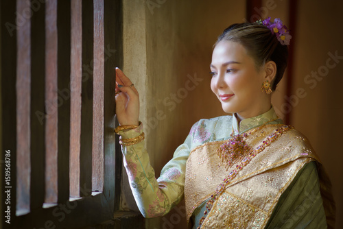 Pretty Asian women in traditional Thai dress. Beautiful traditional Thai dresses by Asian Buddhists make merit at the Temple a tourist attraction at Wat Ton Kien Temple Chiang Mai, Thailand.