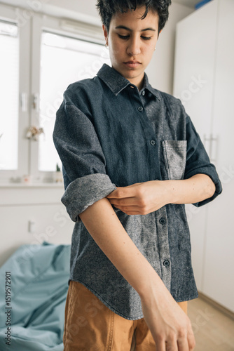 Girl rolling up sleeves getting ready in the morning
