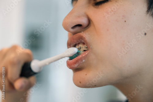 Teenager girl brushing teeth with braces during morning routine