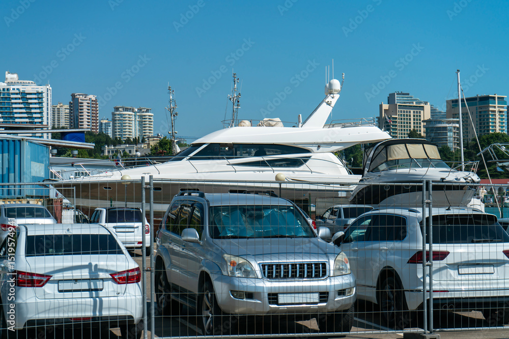 Naklejka premium White boat in the parking lot of the resort town port.