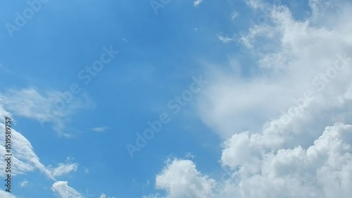 Natural blue sky background with slowly moving white clouds Cumulus. Topics: heaven, cloudscape,  meteorology, weather, climate, beauty of nature, air space