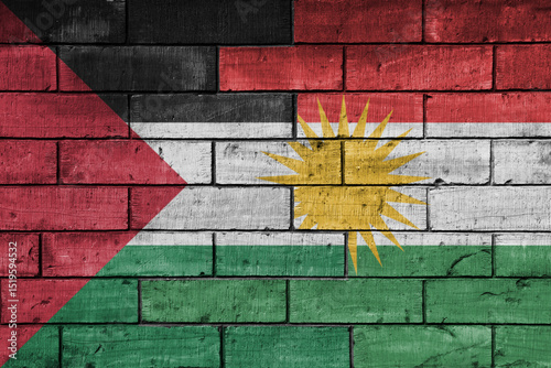 colourful painted big national flag of palestine and flag of kurdistan on a massive old brick wall background. concept