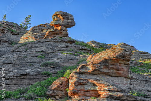 Rocks with a stone resembling a skull on top of the mountain. Kazakh expanses, Mount Ku Egendybulak. Summer autumn landscape