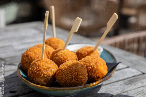 Dutch bitterbal in a bowl; traditional fried pub snack appetizer with mustard