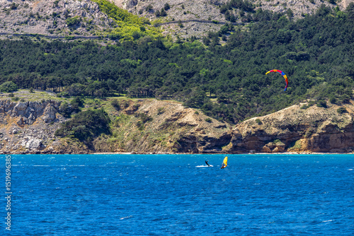 Fototapeta Naklejka Na Ścianę i Meble -  Windsurfing and paragliding in the bay by the beach in Baska on the island of KRK,