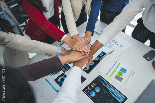 Fotografie Business people stacking hands together showing teamwork and unity in achieving