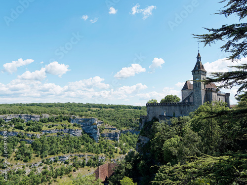 The religious city of Rocamadour is built against a cliff overlooking the Alzou Canyon. At the summit, its castle and the Belvedere of the ramparts, a belfry with a clock on the north side tower photo