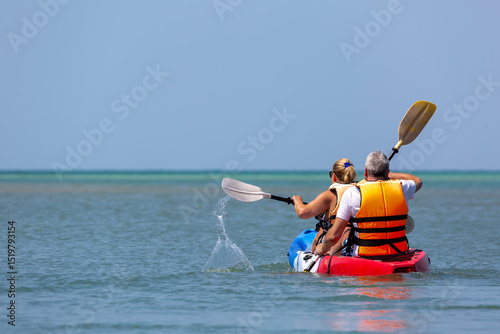 Middle aged couple kayaking in Thailand, Image shows the back view of a middle aged couple kayaking in the gulf of Thailand
