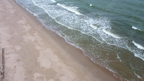 Aerial view of a beautiful summer beach with sea foam and turquoise waves. Perfect for tropical nature, coastal landscapes, vacation themes, and relaxing ocean scenery visuals.