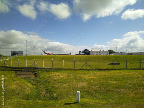 Slika na platnu Airplane on runway under blue sky in rural airfield