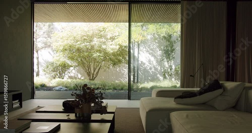 A peaceful and stylish modern living room featuring a large window with a view of a serene garden. The natural light complements the minimalist decor. Modern Home Interior