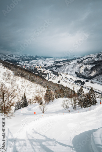 Stunning winter landscape of Ishiuchi Maruyama in Yuzawa, Niigata, Japan. Snow-covered trees, winding road, and mountain slopes create a perfect alpine travel scene in the heart of Japanese winter.