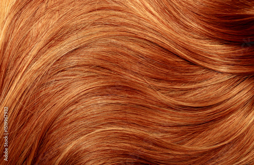 Red hair close-up as a background. Women's long orange hair. Beautifully styled wavy shiny curls. Hair coloring bright shades. Hairdressing procedures, extension.