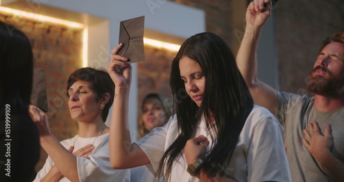 Fotografi Women and man raising offering envelopes during church service, emotional worshi