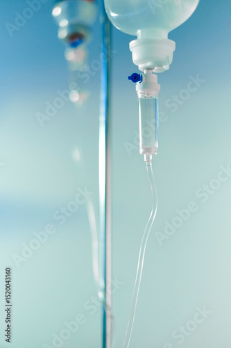 Intravenous drip system with transparent tubing used to deliver fluids and medication in a hospital setting. Standard hospital equipment for patient treatment and hydration therapy.