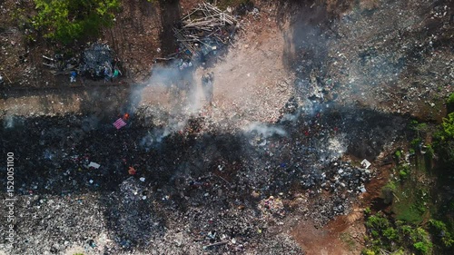 Burning dump in Asia. Pollution by plastic rubbish on landfill, drone view.