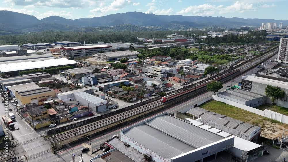 Vista aérea da passagem de trem em Mogi das Cruzes, com composições ferroviárias atravessando a cidade entre ruas e construções