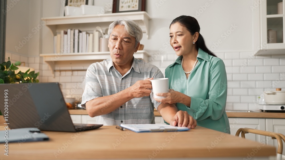 Obraz premium Grandmother holding hot coffee cup and encouraging stressful project manager disappointing about deceasing sales or working problem while old man with casual cloth pointing at laptop screen. Myrmidon.
