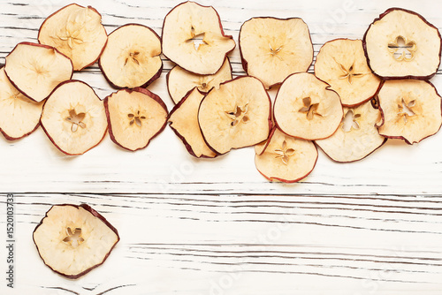 round dried apple chips on wooden background