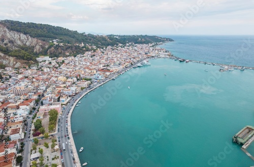 Fototapeta Naklejka Na Ścianę i Meble -  Vivid colors capture the essence of Zakynthos, where bustling streets meet mesmerizing waters on a sunny summer day. Tourists enjoy the lively atmosphere and breathtaking scenery